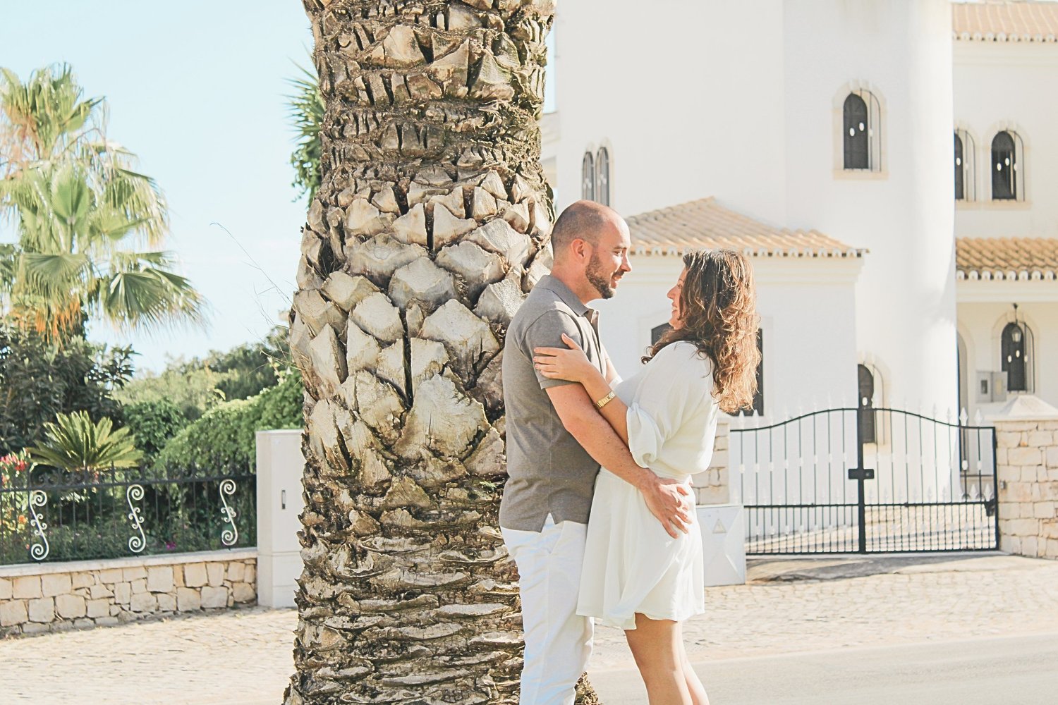 Couple by a villa and palm tree, Algarve
